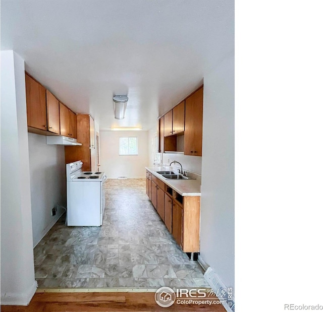 kitchen featuring a sink, brown cabinets, light countertops, and white range with electric cooktop