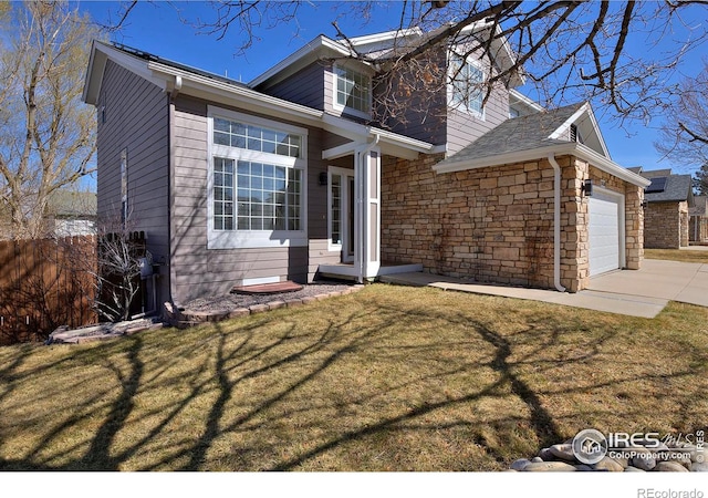 view of front facade with fence, concrete driveway, a front yard, a garage, and stone siding