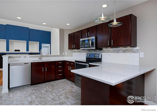 kitchen featuring pendant lighting, a sink, tasteful backsplash, stainless steel appliances, and a peninsula