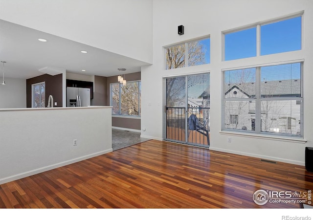 interior space with a sink, visible vents, baseboards, and wood finished floors