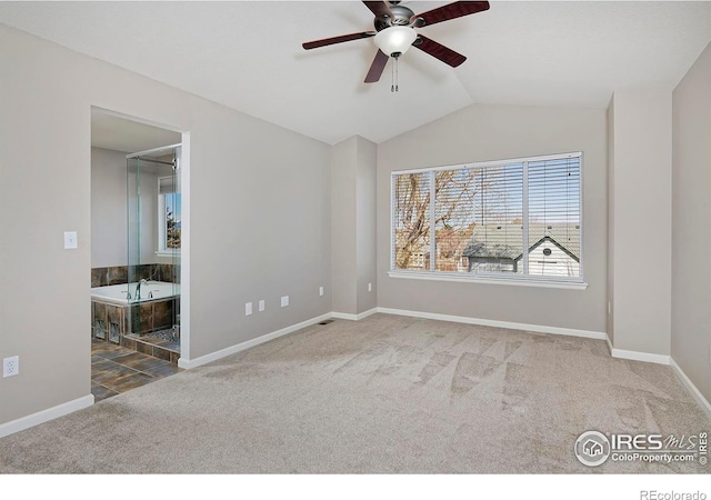 unfurnished bedroom featuring baseboards, lofted ceiling, carpet, and connected bathroom