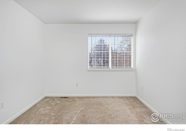 carpeted spare room with baseboards