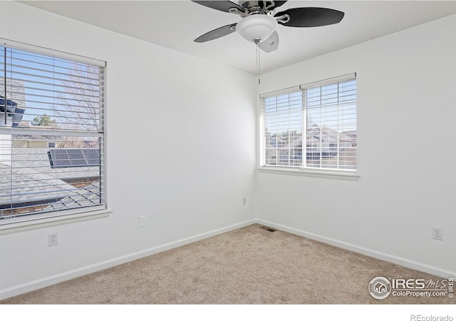 carpeted spare room with baseboards and ceiling fan