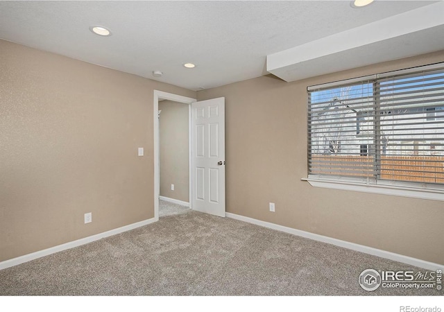 spare room with recessed lighting, baseboards, and carpet