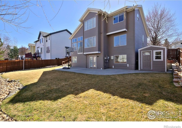 rear view of house with a patio, a yard, a storage shed, an outdoor structure, and fence private yard