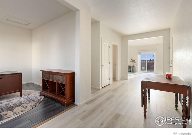 hall with baseboards and wood finished floors