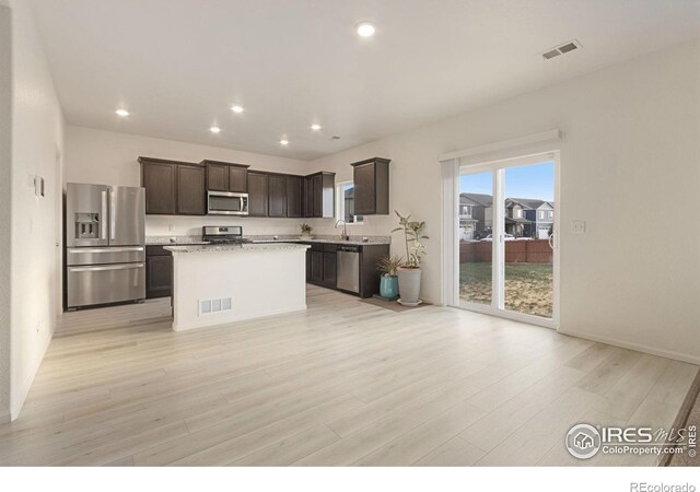 kitchen with visible vents, dark brown cabinets, stainless steel appliances, and light wood-style floors