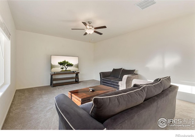 carpeted living area featuring visible vents, baseboards, and a ceiling fan