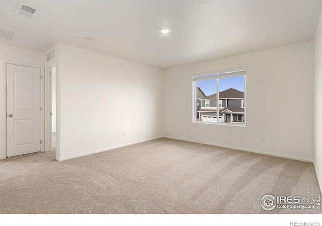 empty room featuring baseboards, visible vents, and carpet floors