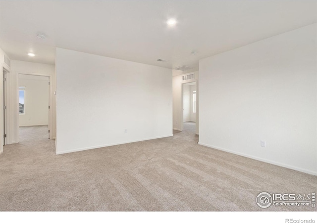 spare room with recessed lighting, baseboards, carpet floors, and visible vents