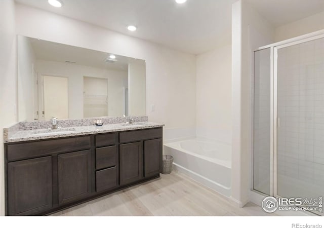 bathroom with a sink, a stall shower, and a bath