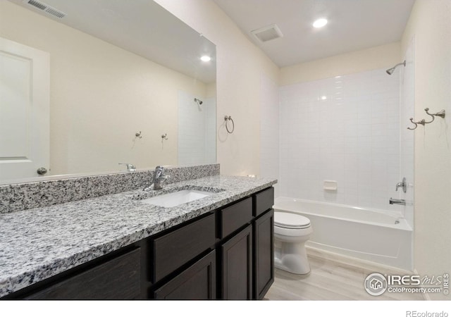 bathroom featuring visible vents, toilet, shower / bath combination, wood finished floors, and vanity