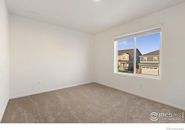 empty room featuring baseboards and carpet