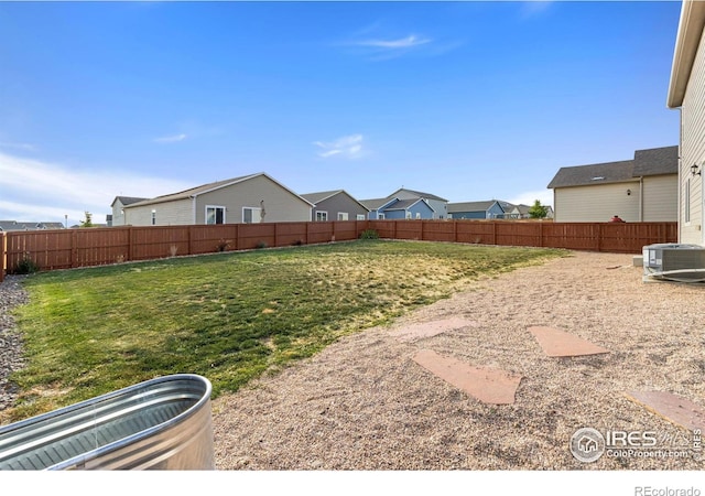 view of yard with central AC unit and a fenced backyard