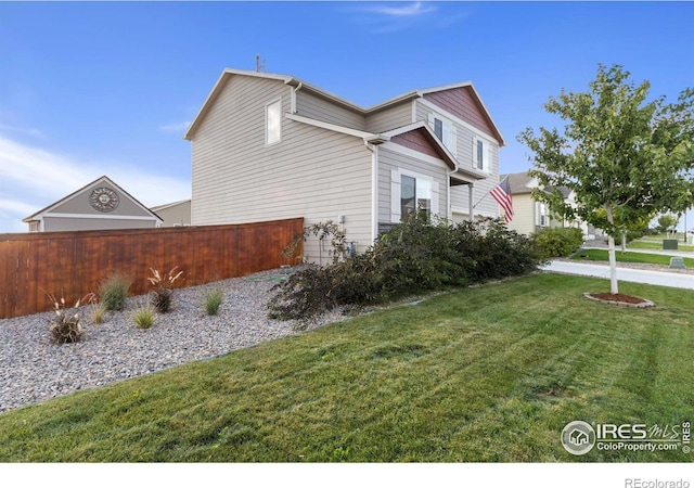 view of home's exterior with a yard and fence