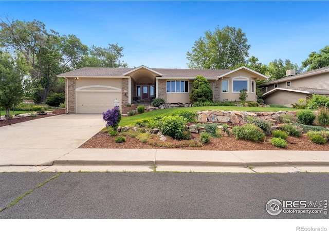 view of front facade with brick siding, stucco siding, concrete driveway, and a garage