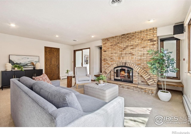 carpeted living area with visible vents, recessed lighting, a brick fireplace, and a baseboard heating unit