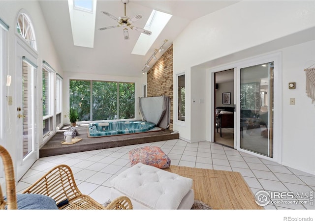 sunroom / solarium featuring vaulted ceiling with skylight and a hot tub