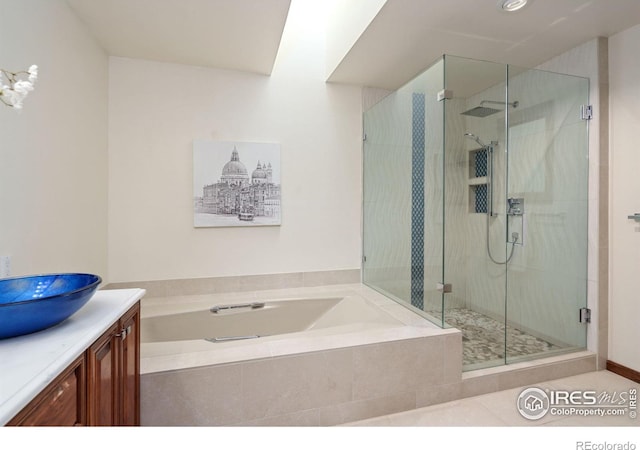 full bathroom featuring a garden tub, a stall shower, and vanity