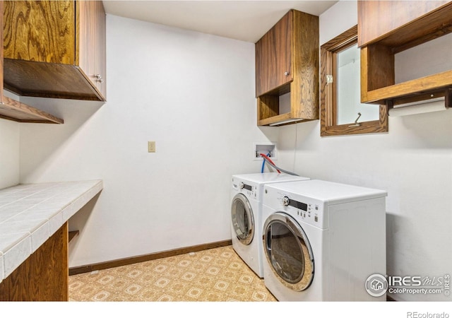 laundry room with washer and dryer, cabinet space, and baseboards