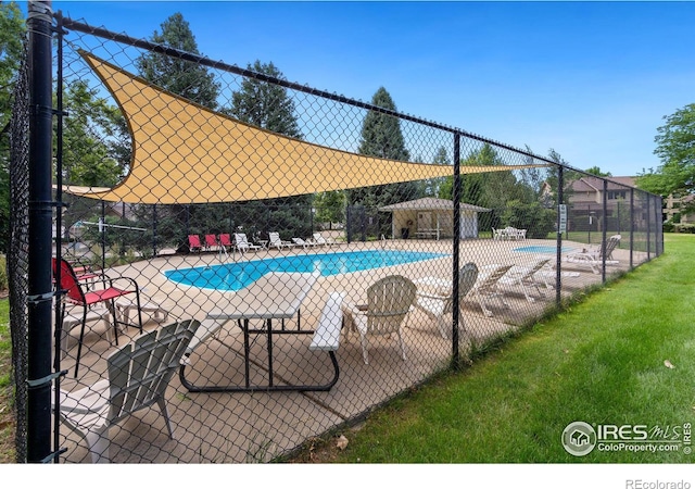 community pool with a patio and fence