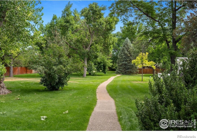 view of property's community with a yard and fence