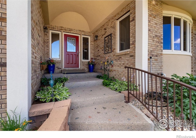 view of exterior entry featuring brick siding