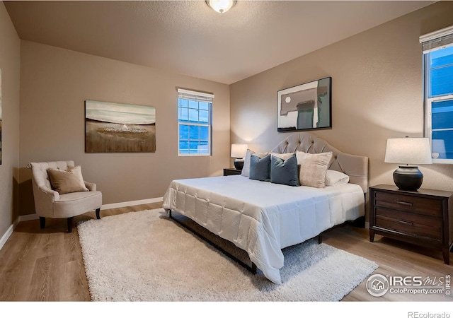 bedroom featuring baseboards and wood finished floors