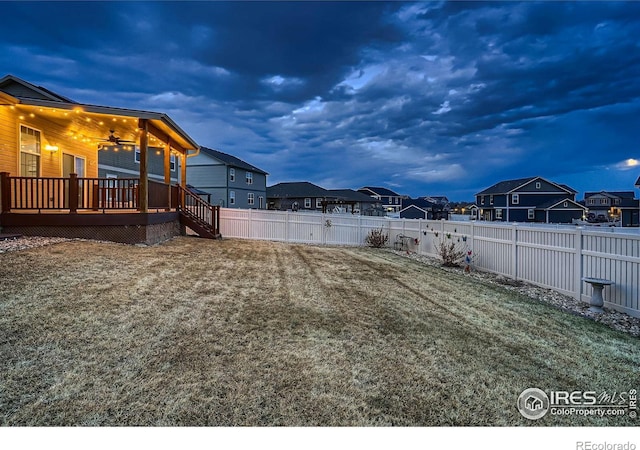 view of yard featuring a wooden deck, a residential view, a ceiling fan, and a fenced backyard