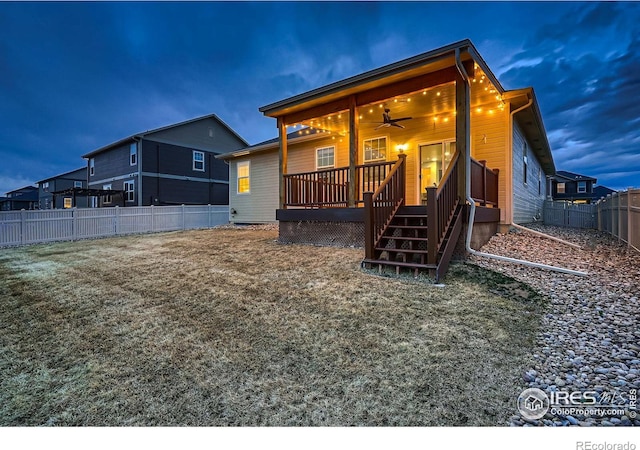 back of property with a deck, a fenced backyard, and a ceiling fan