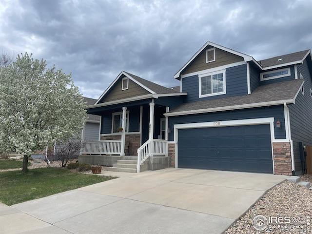 craftsman inspired home featuring a garage, stone siding, covered porch, and concrete driveway