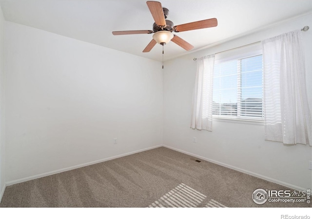 unfurnished room with visible vents, a ceiling fan, baseboards, and carpet floors