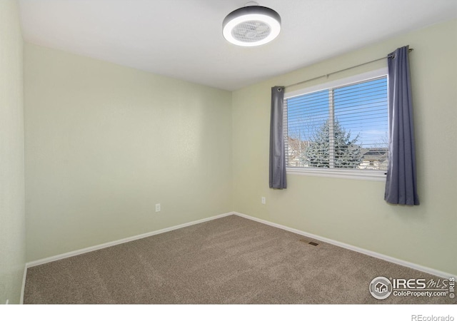 spare room with visible vents, baseboards, and carpet