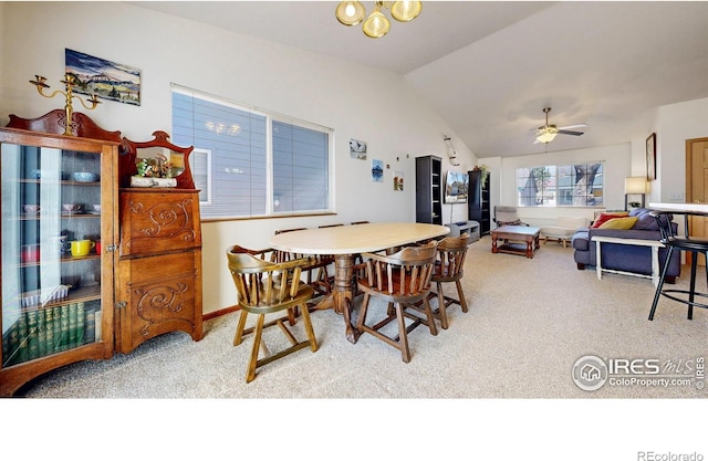 carpeted dining area featuring a ceiling fan and vaulted ceiling