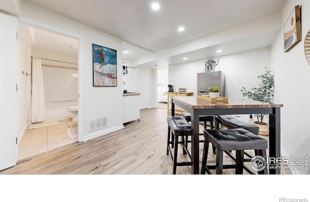 dining room with light wood finished floors, visible vents, recessed lighting, and baseboards