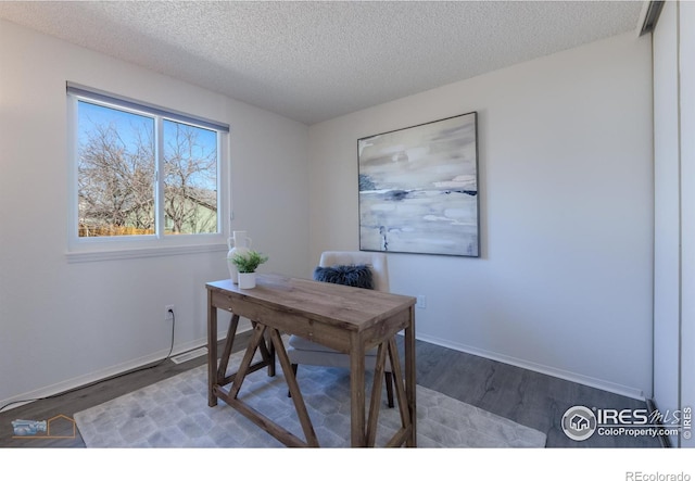 office space featuring wood finished floors, baseboards, and a textured ceiling