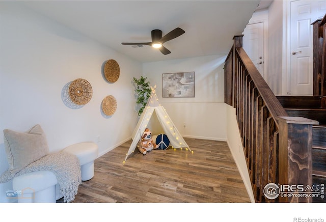 rec room with baseboards, a ceiling fan, and wood finished floors