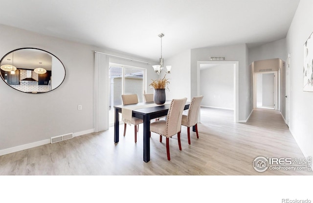 dining area with visible vents, baseboards, a notable chandelier, and light wood-style flooring