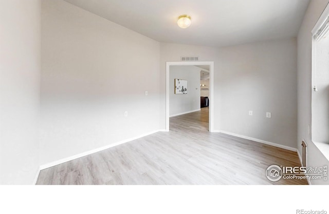 unfurnished room with visible vents, baseboards, and wood finished floors