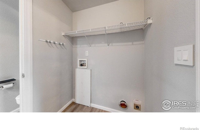 clothes washing area featuring light wood finished floors, baseboards, washer hookup, laundry area, and electric dryer hookup