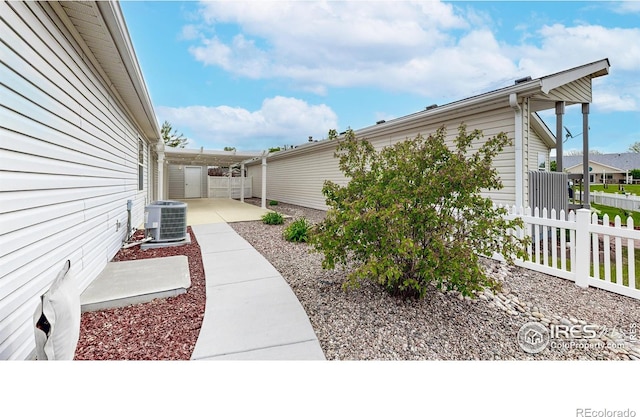 view of property exterior featuring a patio, central AC, and fence