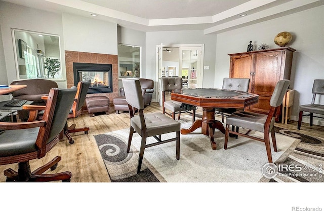 dining room with light wood-style flooring and a fireplace