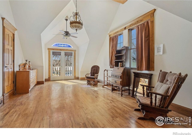 entrance foyer with baseboards, lofted ceiling, a ceiling fan, and wood finished floors