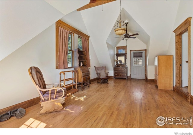 entrance foyer with baseboards, lofted ceiling, wood finished floors, and a ceiling fan