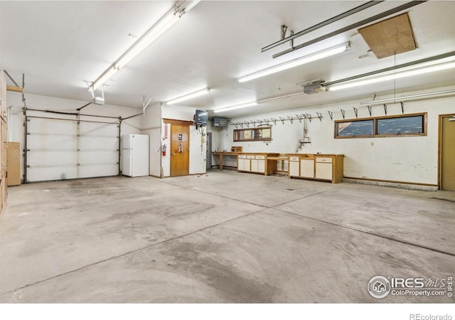 garage featuring a garage door opener and freestanding refrigerator