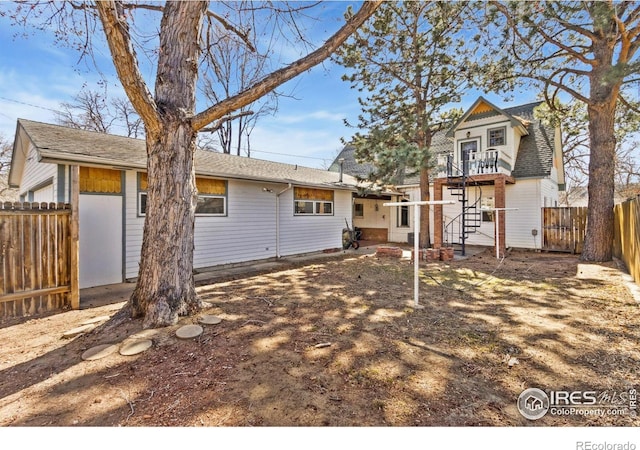 rear view of property with stairway and fence