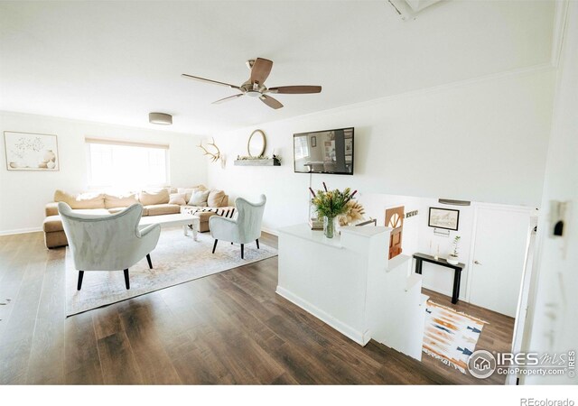 living room with baseboards, a ceiling fan, dark wood-style flooring, and ornamental molding