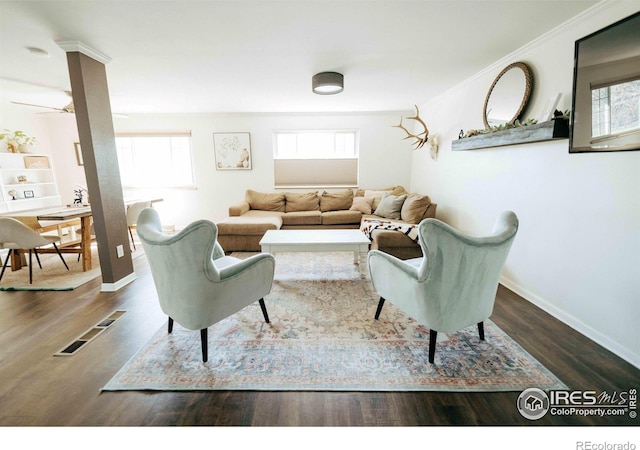 living room with crown molding, plenty of natural light, wood finished floors, and baseboards