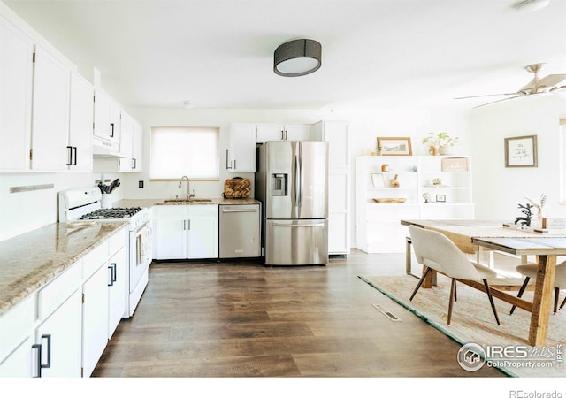 kitchen with dark wood-type flooring, under cabinet range hood, appliances with stainless steel finishes, white cabinetry, and a sink