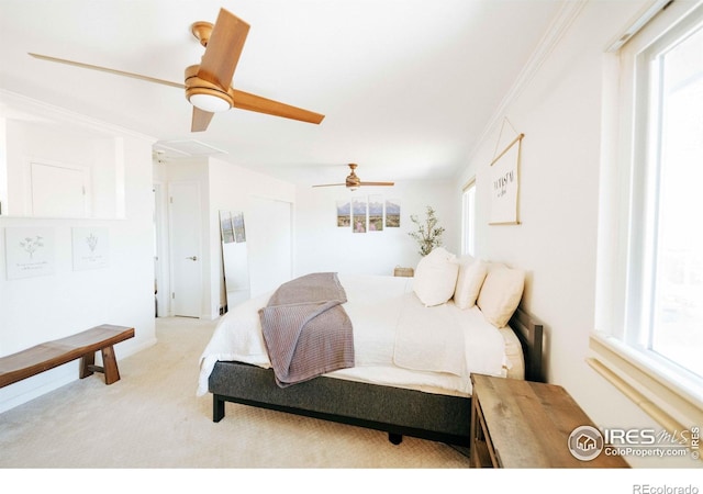 carpeted bedroom featuring ornamental molding and a ceiling fan